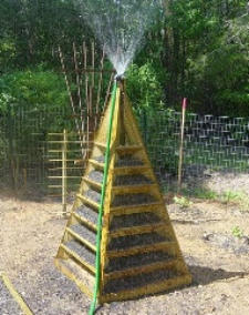 Watering the pyramid planter with a hose